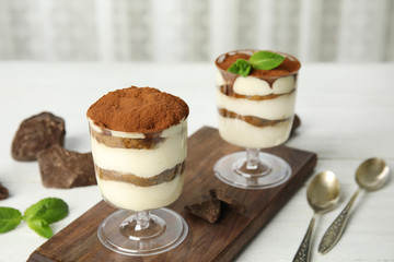 Composition with two glasses of tiramisu cake and chocolate on table