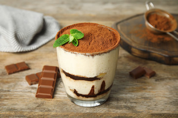 Glass of tiramisu cake and chocolate on wooden table
