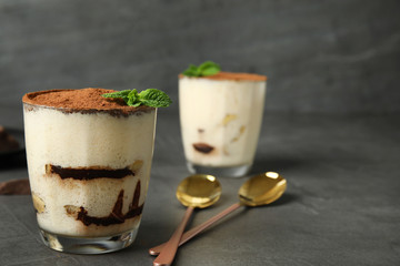 Tiramisu cake in glass on table, space for text