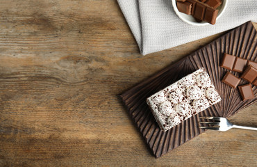 Flat lay composition with tiramisu cake on wooden table, space for text