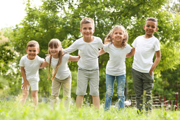 Fototapeta premium Group of children huddling in park. Volunteer project