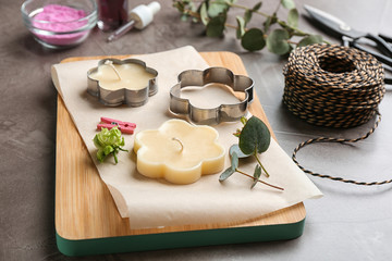 Handmade candles with cutters on stone background
