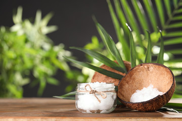 Composition with natural organic coconut oil on wooden table. Space for text