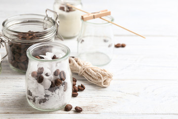 Glass jar, wax and coffee beans for making handmade candle on wooden table. Space for text