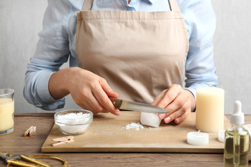Woman making decorative aroma candle at table, closeup