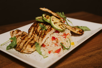 Grilled chicken with rice and vegetables by the glass of juice