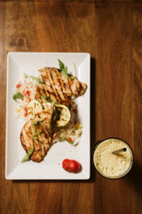 Grilled chicken with rice and vegetables by the glass of juice