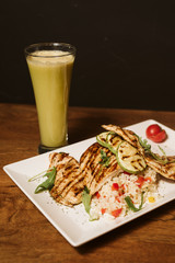 Grilled chicken with rice and vegetables by the glass of juice