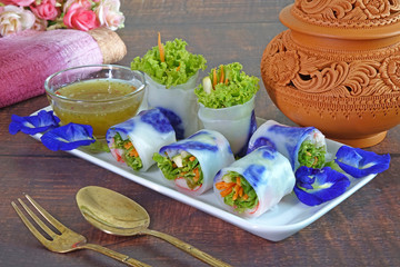 Spring rolls : Edible flowers spring rolls. Beautiful and delicious Thai cuisine, made from butterfly pea flowers, carrot, and vegetables wrapped with rice paper, served with lemon and chili sauce