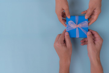 Son gives a gift to dad. Fathers day concept. Blue paper envelope with text 