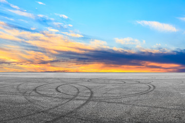 Empty asphalt race track and sunset sky