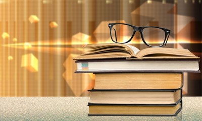 Collection of old books  and glasses on background