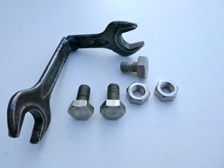 Wrench, old, self-welded, bent to 90 degrees, with screws and nuts.   Top view, isolated on light...