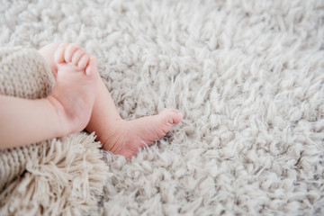 Closeup  newborn baby feet on fluffy blanket. Copy space