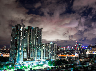 Blurred background of city views (high buildings, condominiums) and night lights of road traffic