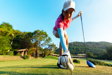 hand of woman golf player gentle put a golf ball onto wooden tee on the tee off, to make ready hit...