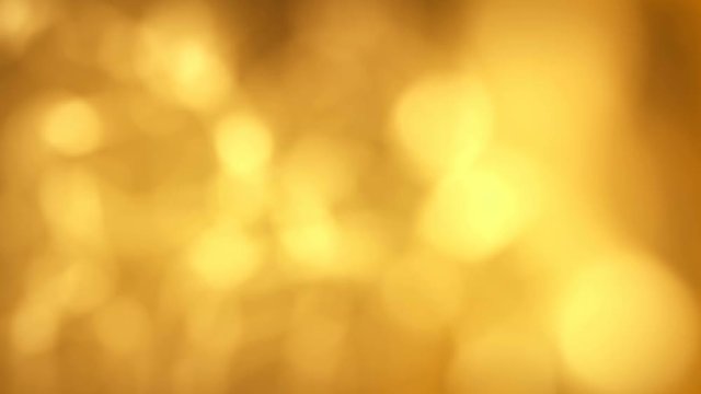 Golden colored shiny blurry light particles background. 4k resolution.