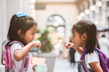 Back to school. Two cute asian child girls with school bag playing together after school in the school