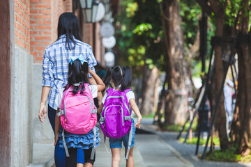 Back to school. Asian mother and daughter pupil girl with backpack holding hand and going to school together