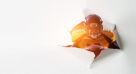 Paper breakthrough hole effect and football player. Mixed media