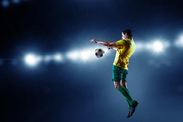 Fototapeta na wymiar Soccer player on stadium in action. Mixed media