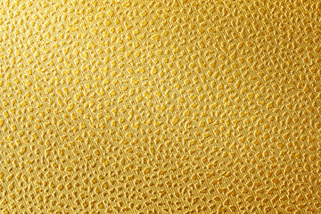 Surface of leatherette gold color textured background.