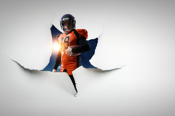 Obraz premium Paper breakthrough hole effect and football player. Mixed media