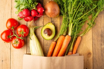 Paper shopping bag. Fresh vegetables. On wooden background. Veggie set.flat lay