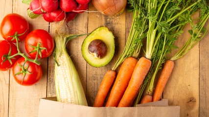 Paper shopping bag. Fresh vegetables. On wooden background. Veggie set.flat lay