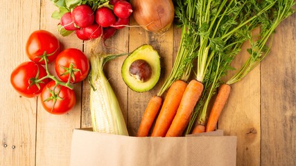 Paper shopping bag. Fresh vegetables. On wooden background. Veggie set.flat lay