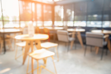 Blurred background cafe coffee shop with sun light. abstract of modern table design in restaurant.