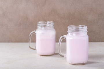 Obraz na płótnie Canvas Strawberry smoothie in glass jars