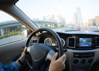 Commuting woman driving car on city road