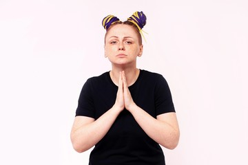 Portrait of woman in casual clothes looking camera, holding hands folded praying. The woman has dreadlocks on her head, freckles on her face. Isolated on white background. Mock up copy space.