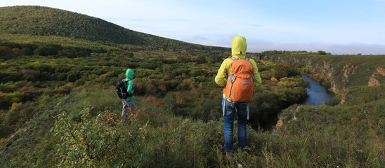 Obraz premium women hiker friends with backpack hiking in the autumn hills