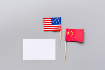 Creative top view flat lay of China and USA flags, mockup and copy space on gray background in minimal style. Concept of trade war between USA and China