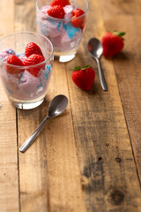 Ice cream with strawberries on wooden background. Vertical photo. Summer mood