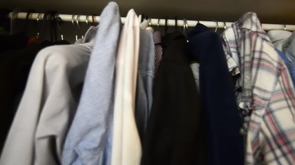 inside of a mans wardroobe, shirts clothes on the hangers