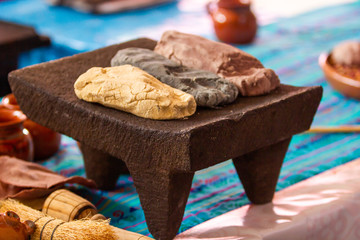 dough of three different types of corn on a metate, mealing stone, mexican culinary, yellow corn, red corn, pink corn