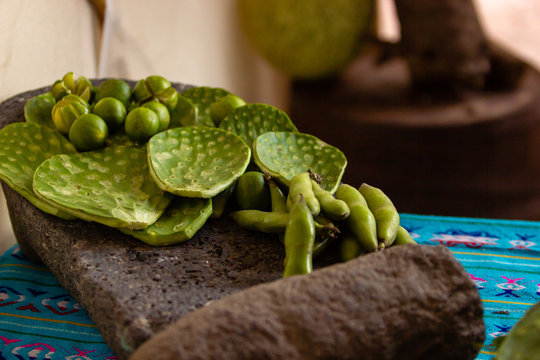 nopales, green chile, and green tomato on a metate,  mealing stone