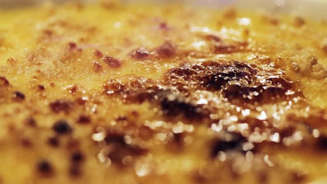 Cooking, making creme brulee caramel traditional French dessert using cooking burner, torch to make crispy crust from brown sugar.