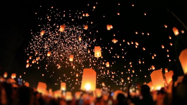 Amazing lanterns of light is released into the night sky by multi ethnic crowd. Celebrate lantern festival of light in Yeepeng festive at Chiangmai, Thailand. Low angle, extreme wide shot. Tilt-Shift.