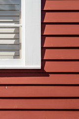 White window on red painted house, cropped 2
