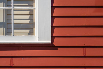 White window on red painted house, cropped