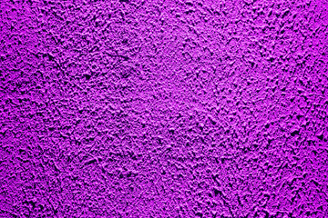 Brightly lit surface covered with bright purple plaster. Trend color