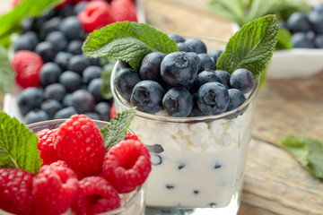 Cottage cheese with cream, raspberry and blueberry garnished with fresh mint.