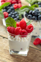 Cottage cheese with cream, raspberry and blueberry garnished with fresh mint.