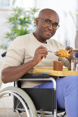 relaxed handsome man in wheelchair drinking coffee