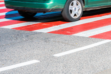 Car on a red and white pedestrian crossing. car on road