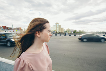 portrait of a beautiful girl on the background of the urban landscape